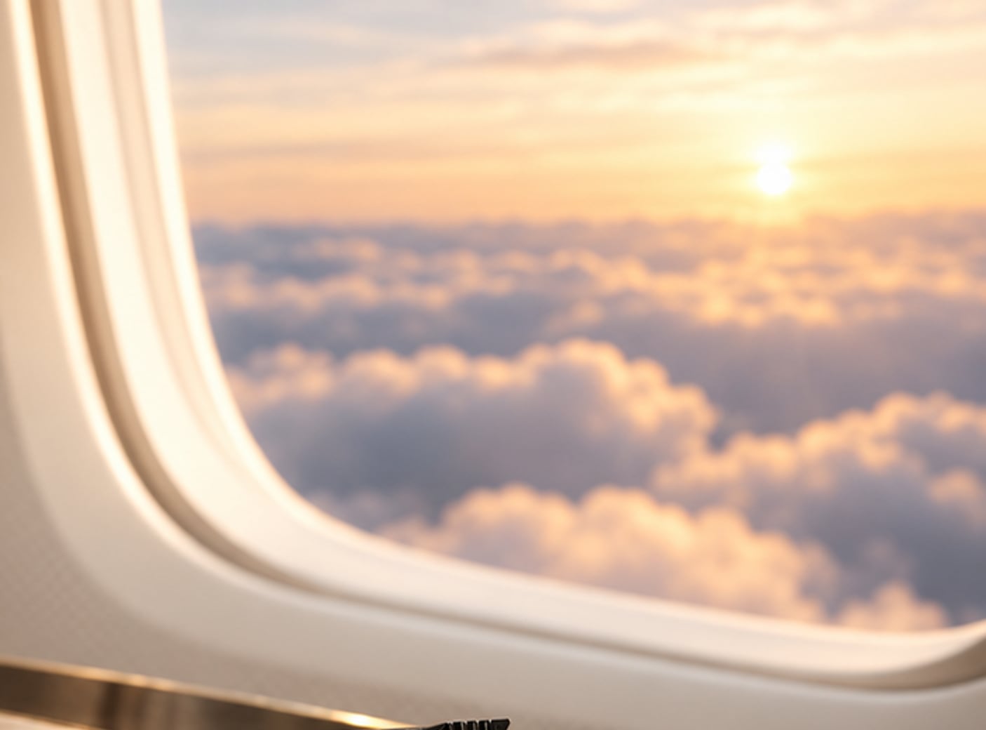 Ventanilla de avión con un mar de nubes al atardecer